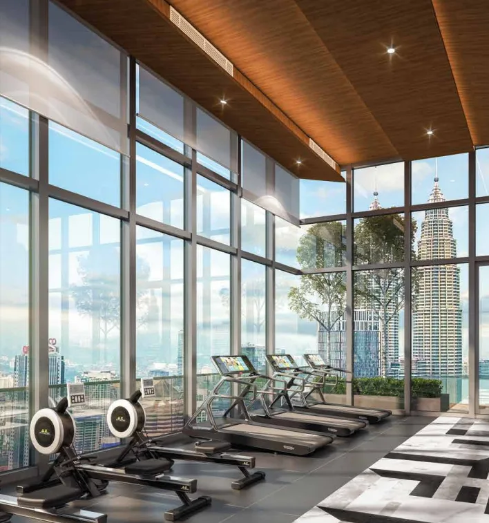 PV Face Suites gym with treadmills and rowing machines overlooking a city skyline with Petronas Twin Towers in Jalan Sultan Ismail, Freehold property development, render