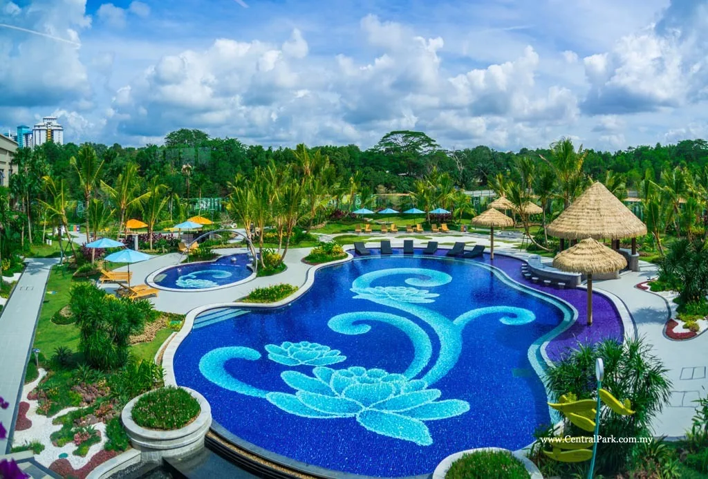  Country Garden Central Park The image shows a large swimming pool with a floral mosaic design, surrounded by lush greenery and thatched-roof cabanas. in Johor Bahru, Freehold property development, photo