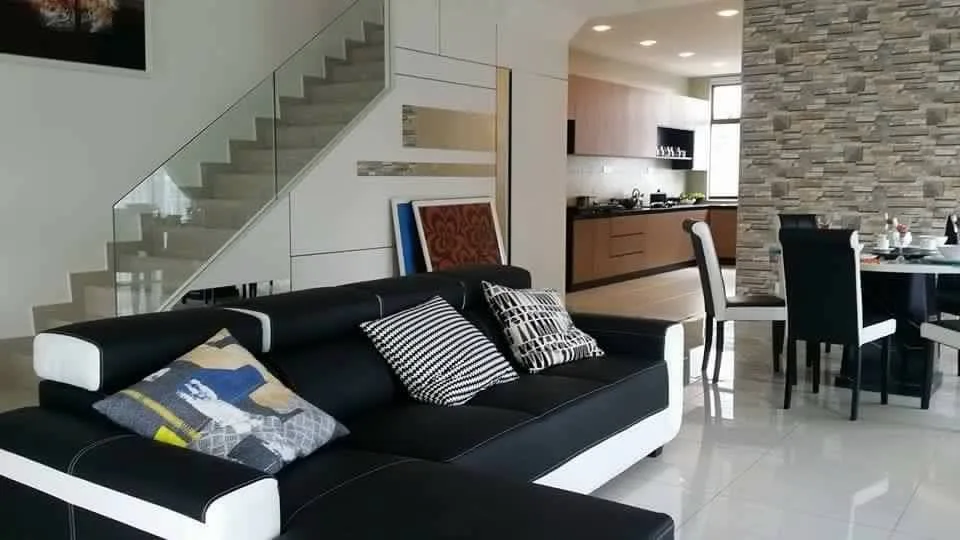 Taman Bestari Indah - KSL Lily The image shows the interior of a house, featuring a living room with a black and white sofa, a staircase, a dining area, and a kitchen in the background., Freehold property development, photo