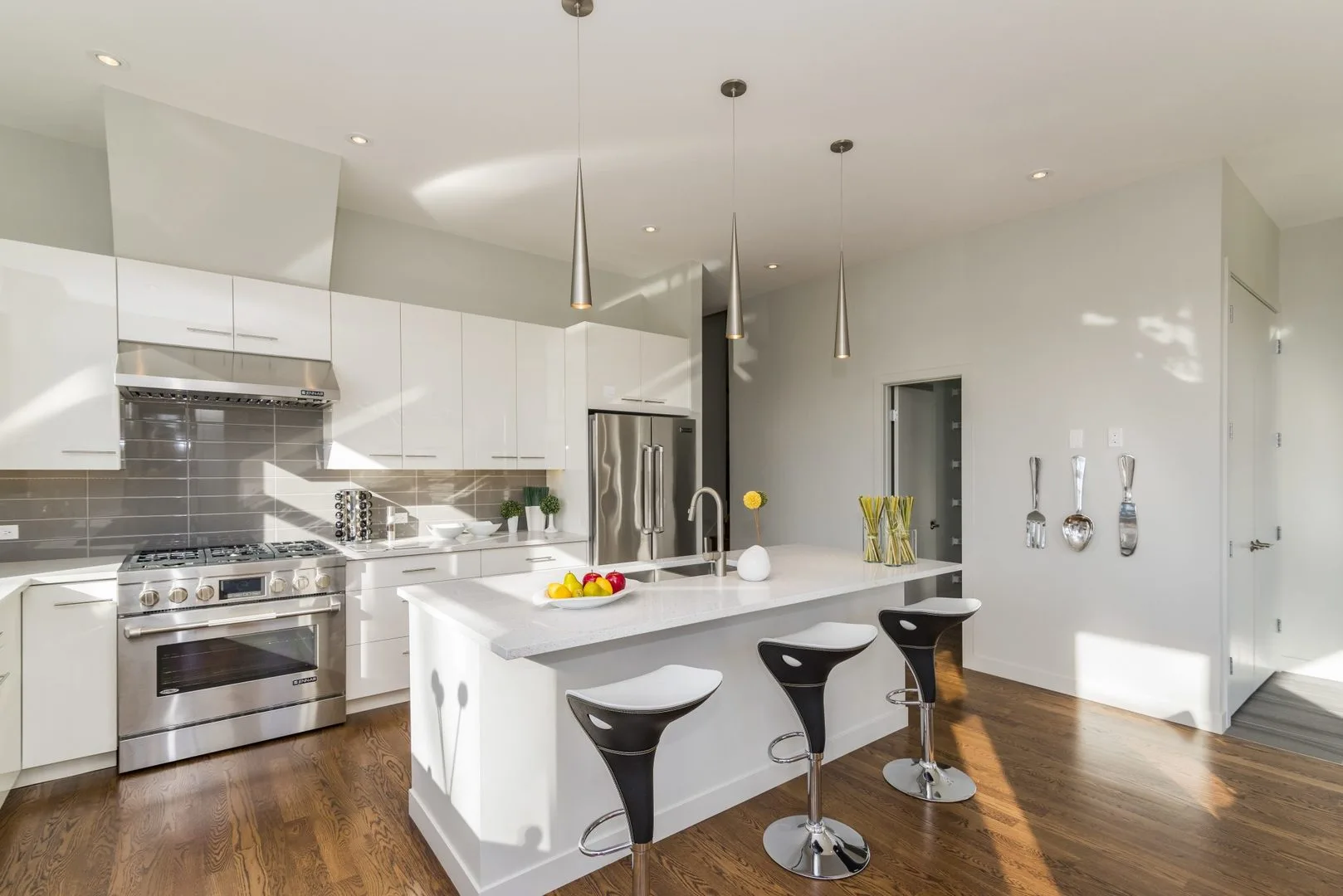 Livista Bandar Sri Damansara This image showcases a modern kitchen with white cabinetry, stainless steel appliances, a central island with bar stools, and hardwood flooring. in Bandar Sri Damansara, Freehold property development, photo